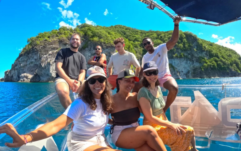 Groupe d'amis souriants profitant du soleil et du paysage lors de l'excursion en mer sur le Crystal Boat.