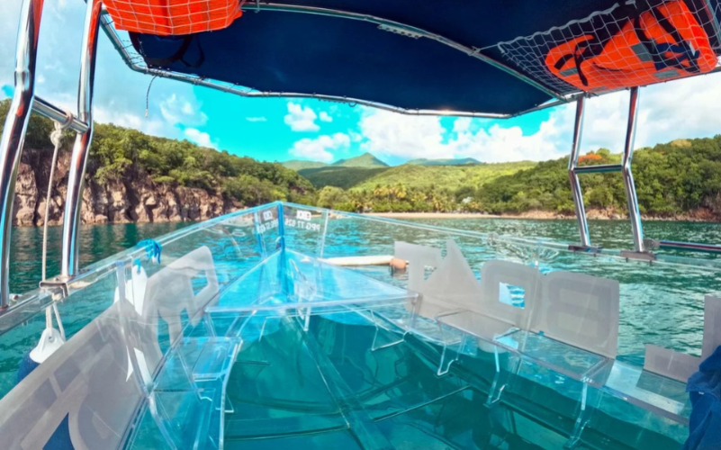 Panorama depuis l'avant du bateau transparent face à la côte verte et sauvage de Pointe-Noire en Guadeloupe.